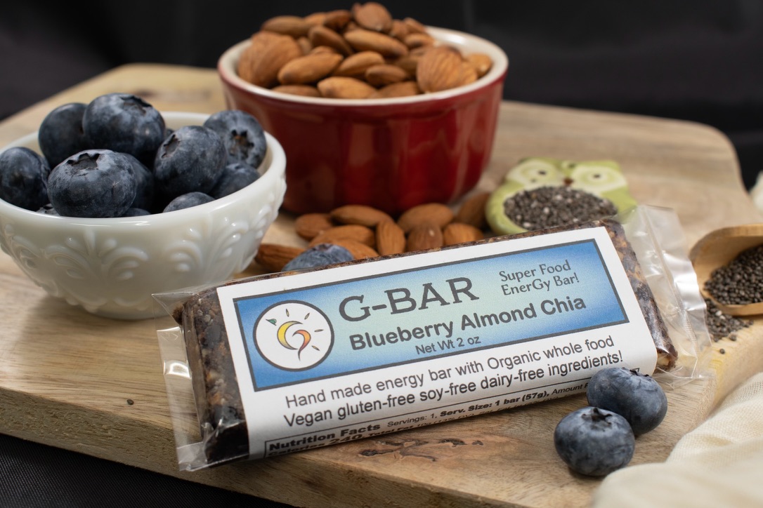 A wrapped G-Bar on a wooden board beside ingredient bowls.